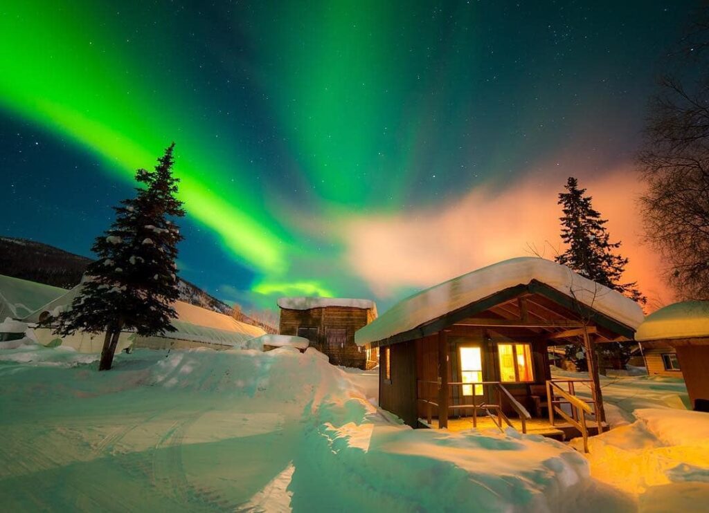 Northern lights over the cabins at Chena Hot Springs Resort. Photo by: Chena Hot Springs Resort
