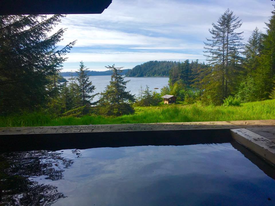 Scenic views of the bay and surrounding lush forest from the Goddard Hot Springs tub. Photo by: Visit Sitka